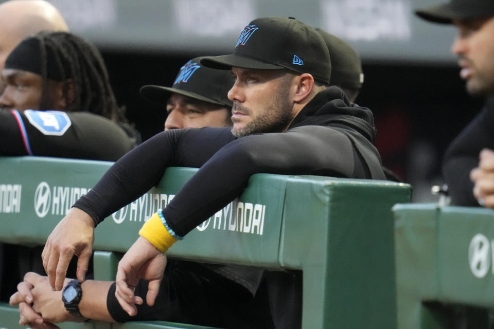 Miami Marlins manager Skip Schumaker, center, stands in the dugout during the first inning of the team's baseball game against the Pittsburgh Pirates in Pittsburgh, Friday, Sept. 29, 2023. (AP Photo/Gene J. Puskar)