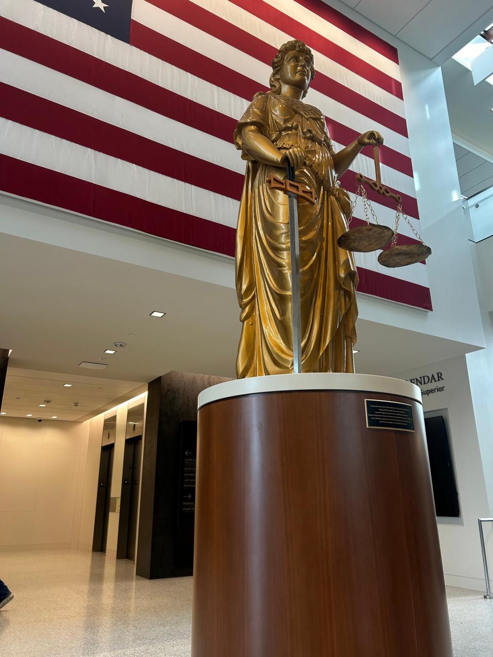 A restored statue of Lady Justice graced by a giant American flag are part of the display in the new Shasta County Courthouse.