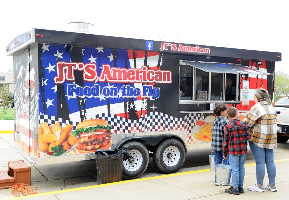 Customers wait to place an order at the JT's American Food on the Fly truck on Saturday, April 1, 2023.