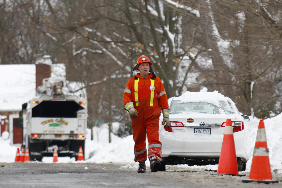 A utility worker walks up the street following a winter storm rolled through Western New York Tuesday, Dec. 27, 2022, in Amherst, N.Y. (AP Photo/Jeffrey T. Barnes)