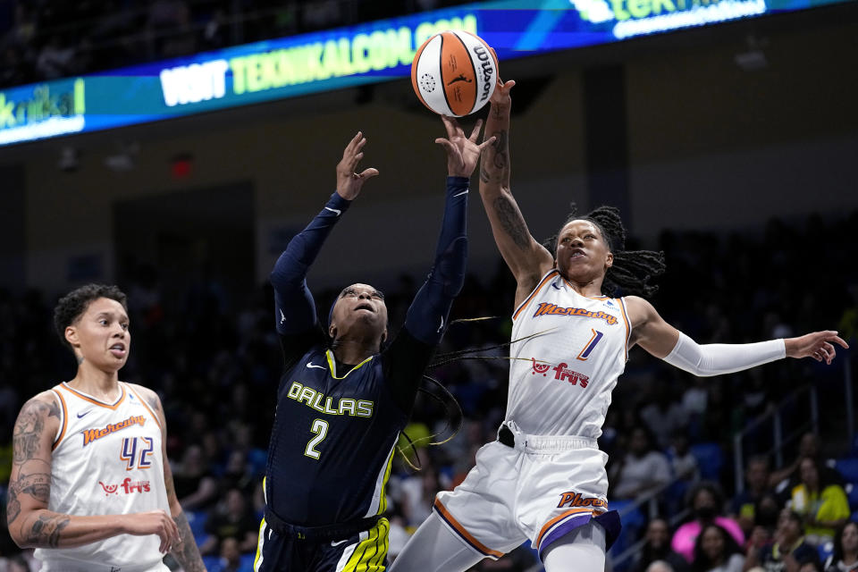 Dallas Wings' Odyssey Sims (2) shoots from between Phoenix Mercury's Brittney Griner (42) and Sug Sutton (1) during the first half of a WNBA basketball game Wednesday, June 7, 2023, in Arlington, Texas. (AP Photo/Tony Gutierrez)