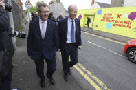 Northern Ireland lawmaker Jeffrey Donaldson, left, leaves the Democratic Unionist Party (DUP) headquarters in Belfast, Northern Ireland, after voting in the party's leadership election, Friday May 14, 2021. Northern Ireland’s largest British unionist party is choosing a new leader Friday, in a contest between Northern Ireland lawmakers Edwin Poots and Jeffrey Donaldson, with only 36 eligible voters and the result due late Friday afternoon. (Brian Lawless/PA via AP)