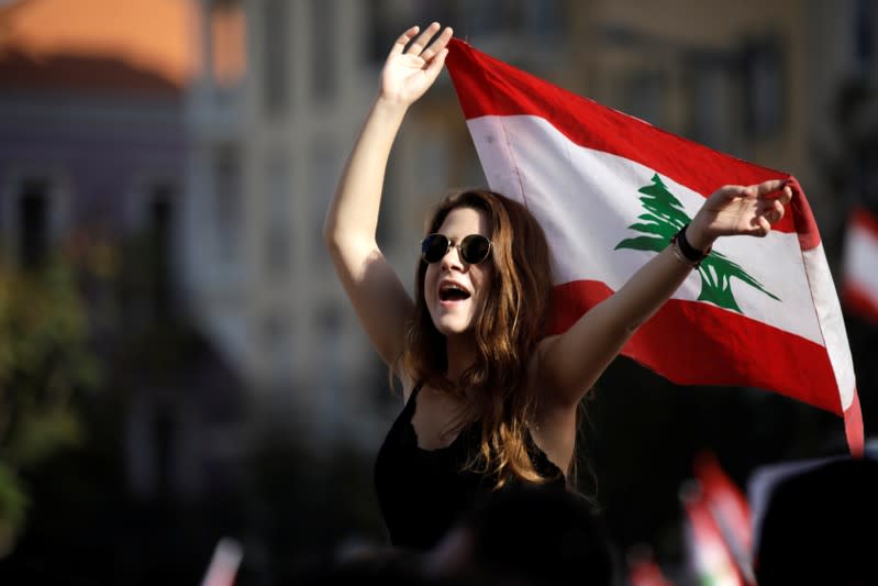 A protester waves a Lebanese flag at a demonstration organised by students during ongoing anti-government protests in Beirut