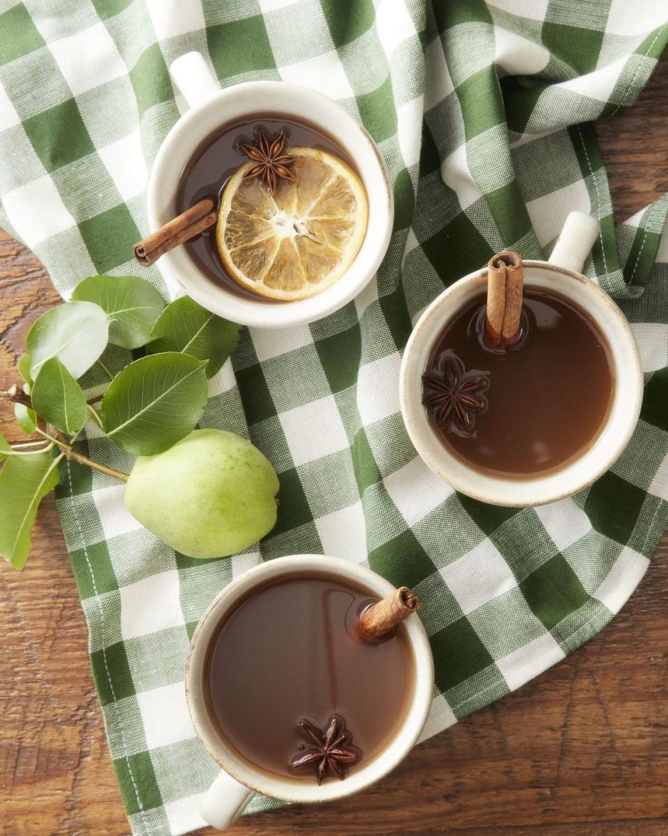 a couple of cups of tea with lemons and a lemon on a table