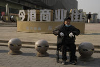 An elderly man sits in a wheelchair near a partially shuttered Evergrande commercial complex in Beijing, Monday, Jan. 29, 2024. Chinese property developer China Evergrande Group on Monday was ordered to liquidate by a Hong Kong court, after the firm was unable to reach a restructuring deal with creditors. (AP Photo/Ng Han Guan)