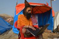 <p>Ein hinduistischer Mönch sitzt in Allahabad, Indien, während des Magh Mela Festivals vor seinem Zelt und arbeitet an seinem Laptop. Das Magh Mela ist eines der größten religiösen Feste des Hinduismus. (Bild: Prabhat Kumar Verma/Pacific Press via ZUMA Wire/dpa) </p>