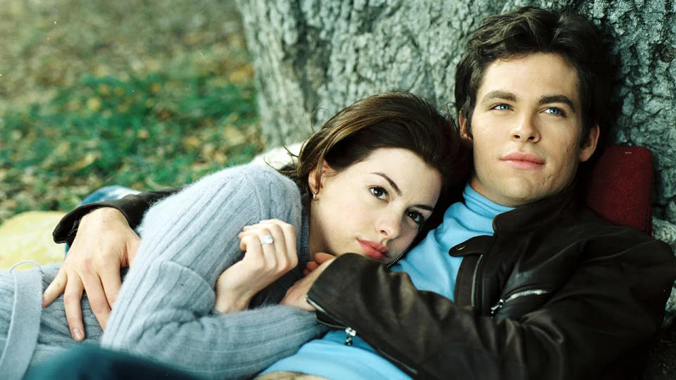 Anne Hathaway in a blue sweater leans against Chris Pine in a blue shirt and dark jacket in "The Princess Diaries 2"