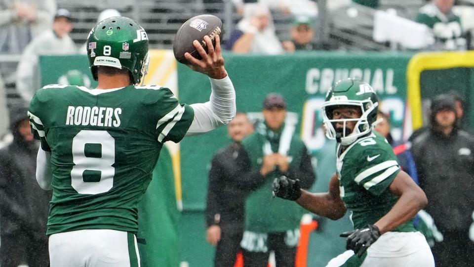 New York Jets quarterback Aaron Rodgers (8) throws complete pass to wide receiver Garrett Wilson (5) against the Denver Broncos in the second half at MetLife Stadium.