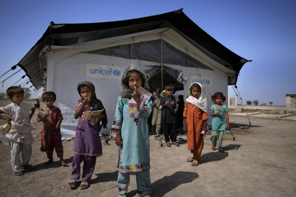 Flood victims leave a school set up in a tent, caused by last year's floods, in Arzi Naich village in Dada, a district of Pakistan's Sindh province, Wednesday, May 17, 2023. Many children are still without schools as authorities struggle to repair the extensive damage. (AP Photo/Anjum Naveed)