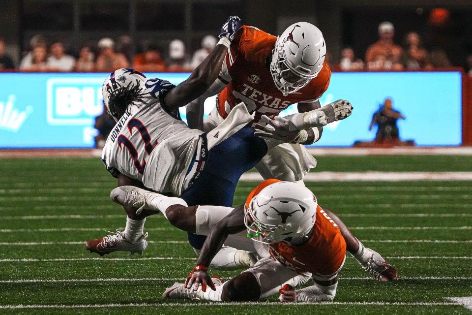 The Longhorns' Morice Blackwell Jr., top, helps bring down Bryson Donnell in the rout of UTSA. The Texas defense has played well despite being overshadowed by an injury to the Heisman-favorite quarterback and an electric performance by his backup.