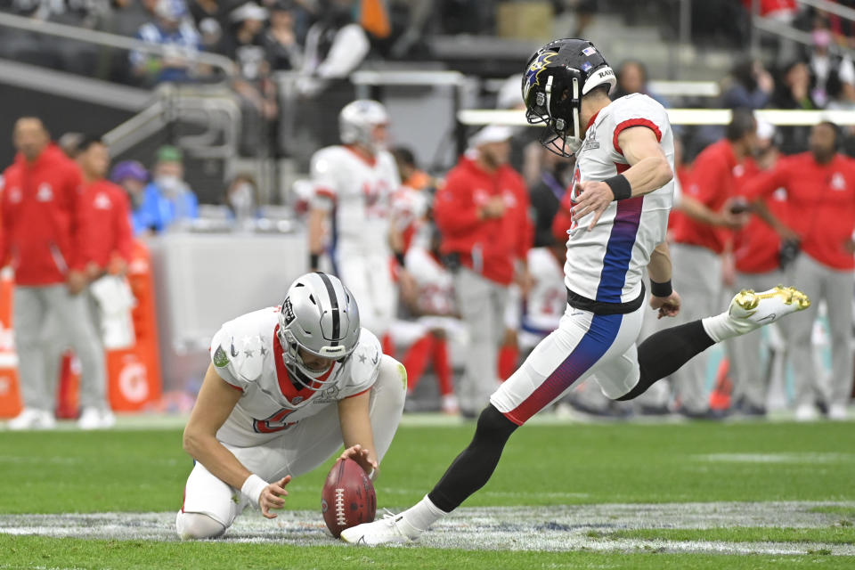 FILE - AFC kicker Justin Tucker of the Baltimore Ravens, right, makes a point-after as AFC punter AJ Cole (6), of the Las Vegas Raiders, holds during the first half of the Pro Bowl NFL football game against the NFC, Sunday, Feb. 6, 2022, in Las Vegas. The NFL is replacing the Pro Bowl with weeklong skills competitions and a flag football game. The new event will be renamed “The Pro Bowl Games” and will feature AFC and NFC players showcasing their football and non-football skills in challenges over several days. (AP Photo/David Becker, File)