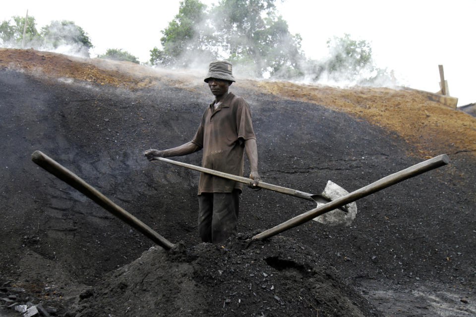 FILE - Sousmane works in a charcoal plant outside Abidjan, Ivory Coast, Nov. 11, 2022. Delegates at the U.N. climate summit, known as COP27 and taking place in Sharm el-Sheikh, Egypt, are discussing greenhouse gas emissions, including those that come from coal. (AP Photo/Diomande Bleblonde, File)