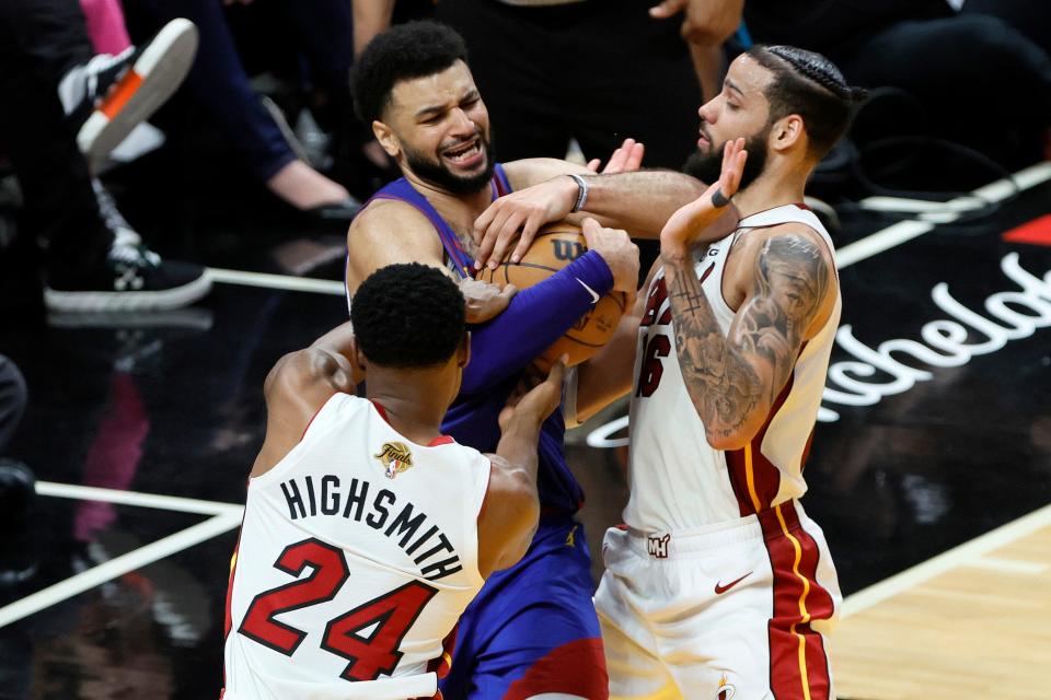 Game 3: Denver Nuggets guard Jamal Murray (27) grabs a rebound against Miami Heat forward Haywood Highsmith (24) and forward Caleb Martin (16).