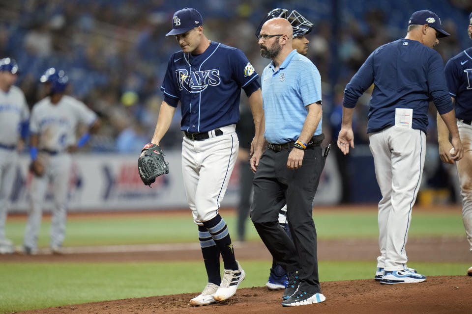 Tampa Bay Rays starting pitcher Shane McClanahan leaves the field with trainer Joe Benge after betting hurt during the fourth inning of a baseball game against the Kansas City Royals Thursday, June 22, 2023, in St. Petersburg, Fla. (AP Photo/Chris O'Meara)
