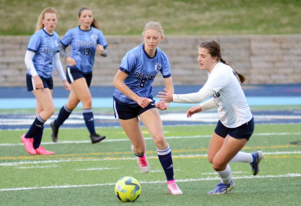 Petoskey's Lillian Premo pushes the ball out of Petoskey's end of the field with a Gaylord player defending and teammates Hope Wegmann and Annie Jones watching from behind Thursday.