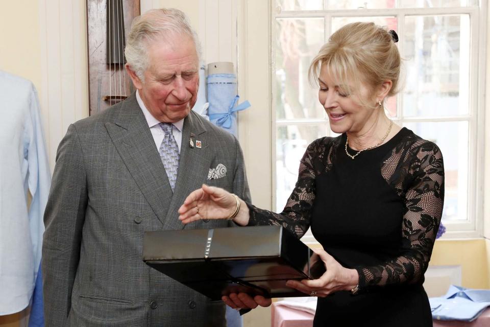 Prince Charles, Prince of Wales receives a present from Emma Willis during his visit (PA)