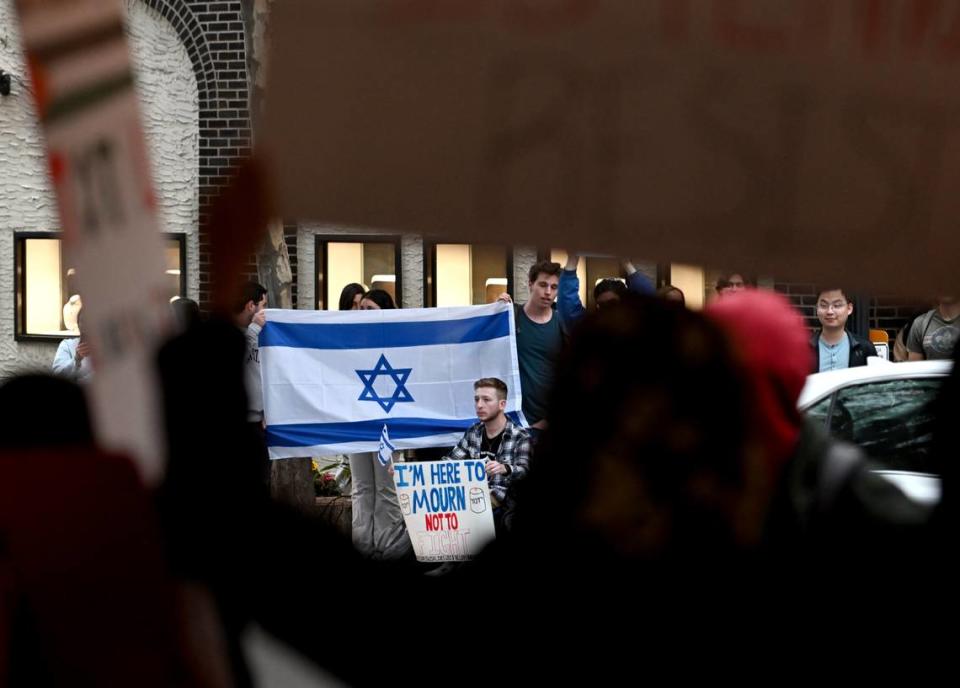 A group holding an Israeli flag sits across the street from the gathering of support for Palestine at the Allen Street gates on Thursday, Oct. 12, 2023. Abby Drey/adrey@centredaily.com