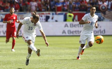 Graham Zusi (L) of the U.S. takes a shot as his teammate Clint Dempsey looks on during their international friendly soccer match against Turkey in Harrison, New Jersey, June 1, 2014. REUTERS/Mike Segar