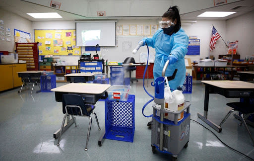 Nov. 9: Guadalupe Duran sprays disinfectant in the school library at Lupine Hill Elementary School in Calabasas, California, one of the first schools to reopen in L.A. County. (Getty Images)