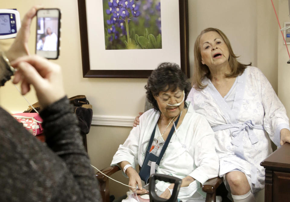 In this Jan. 14, 2014 photo. Irma Myers-Santana, left, and her sister Anna Williamson, right, sing a song as Kim Pappas films them with her cell phone in Houston. Earlier this month the sisters ended up in the same operating room, each getting one lung from the same donor. (AP Photo/Pat Sullivan)