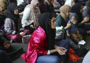 In this Dec. 27, 2019, photo, Amani Al-Khatahtbeh, center, sits near the back of the room at the Islamic Center of New York University during Friday prayers. At 17, she and a group of friends from her local mosque started the blog Muslimgirl.com in response to anti-Muslim bullying they experienced after 9/11. Ten years later, the blog has grown into an online magazine with a global audience. (AP Photo/Jessie Wardarski)