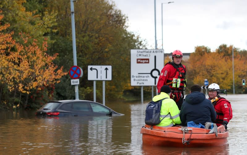 Firefighters and first responders rescue rescue people stranded in a flooded road in central Rotherham, near Sheffield