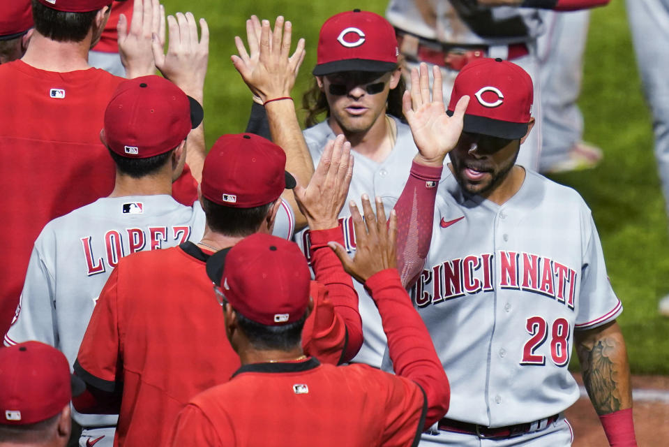 Cincinnati Reds' Tommy Pham (28) and TJ Friedl, top, greet teammates after a 4-0 win over the Pittsburgh Pirates in a baseball game Thursday, May 12, 2022, in Pittsburgh. (AP Photo/Keith Srakocic)