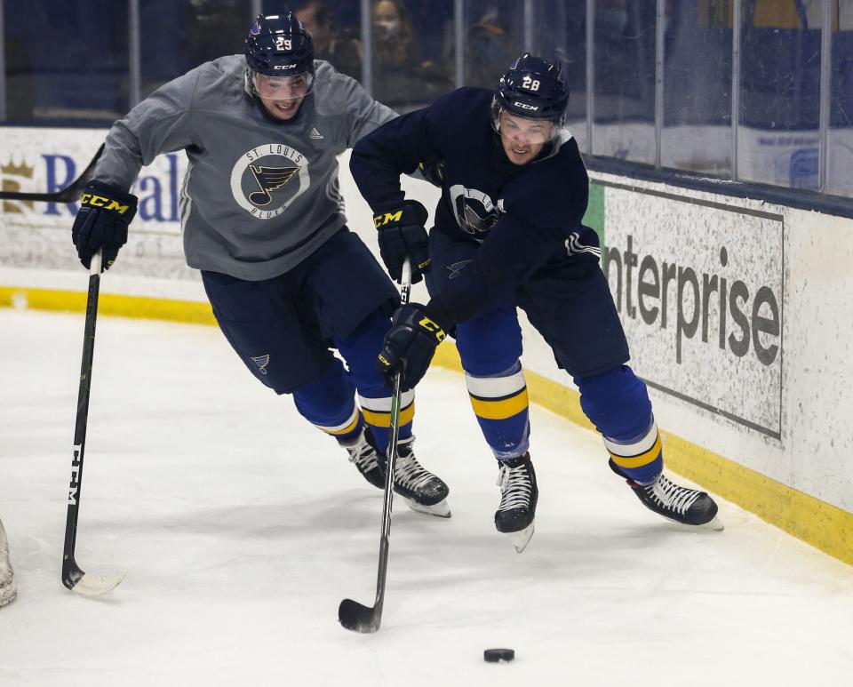 St. Louis Blues left wing Mackenzie MacEachern (28) and defenseman Vince Dunn (29) chase after a puck during NHL hockey practice at the Centene Community Ice Center in Maryland Heights, Mo., Monday, Jan. 4, 2021. (Colter Peterson/St. Louis Post-Dispatch via AP)