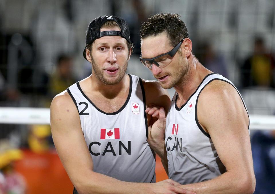 2016 Rio Olympics - Beach Volleyball - Men&#39;s Preliminary - Beach Volleyball Arena - Rio de Janeiro, Brazil - 10/08/2016. Josh Binstock (CAN) of Canada and Sam Schachter (CAN) of Canada react during their match against Austria. REUTERS/Ruben Sprich FOR EDITORIAL USE ONLY. NOT FOR SALE FOR MARKETING OR ADVERTISING CAMPAIGNS.