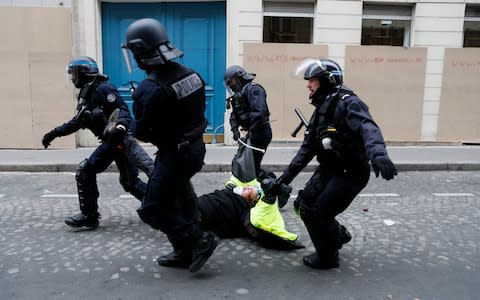 An injured Gilets Jaunes protestor is arrested  - Credit: Photo by Kiran Ridley/Getty Images