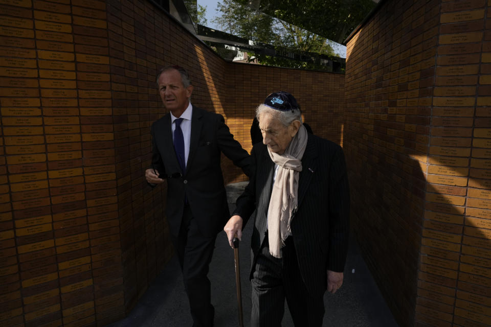 A holocaust survivor walks along walls with name stones after King Willem-Alexander officially unveiled a new monument in the heart of Amsterdam's historic Jewish Quarter on Sunday, Sept. 19, 2021, honoring the 102,000 Dutch victims of the Holocaust. Designed by Polish-Jewish architect Daniel Libeskind, the memorial is made up of walls shaped to form four Hebrew letters spelling out a word that translates as "In Memory Of." The walls are built using bricks each of which is inscribed with the name of one of the 102,000 Jews, Roma and Sinti who were murdered in Nazi concentration camps during World War II or who died on their way to the camps. (AP Photo/Peter Dejong)