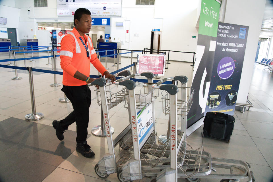 A worker pushes away luggage carts at the Ras al-Khaimah International Airport in Ras al-Khaimah, United Arab Emirates, Wednesday, Oct. 23, 2019. India's low-cost airline SpiceJet announced plans Wednesday to build its first international hub in the United Arab Emirates, offering a pledge of support to Boeing Co. by saying it would use now-grounded 737 MAX aircraft in the operation once regulators approve the planes for flight. (AP Photo/Jon Gambrell)