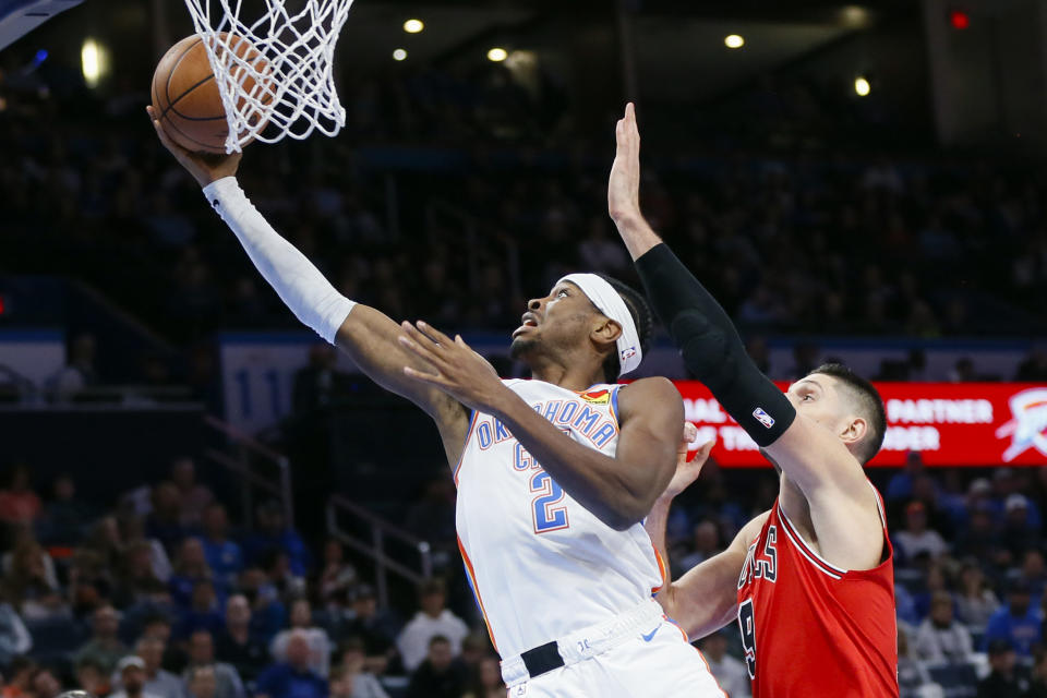 Oklahoma City Thunder guard Shai Gilgeous-Alexander (2) lays up the ball in front of Chicago Bulls center Nikola Vucevic, right, during the first half of an NBA basketball game, Wednesday, Nov. 22, 2023, in Oklahoma City. (AP Photo/Nate Billings)