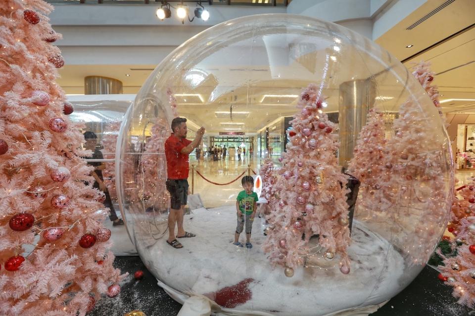 A snapshot of a shopper checking out the Christmas decorations at 1 Utama shopping mall. — Picture by Ahmad Zamzahuri