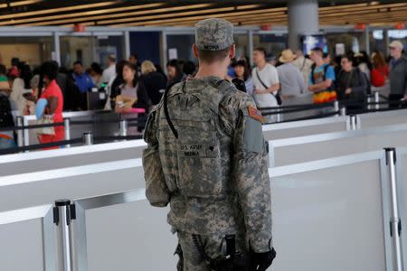 A U.S. Army Specialist monitors the security line at John F. Kennedy international Airport in the Queens borough of New York, U.S., June 29, 2016. REUTERS/Andrew Kelly