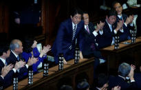 Japan's Prime Minister Shinzo Abe (C) stands as he is re-elected as prime minister while his party lawmakers clap their hands at the Lower House of Parliament in Tokyo, Japan, November 1, 2017. REUTERS/Toru Hanai