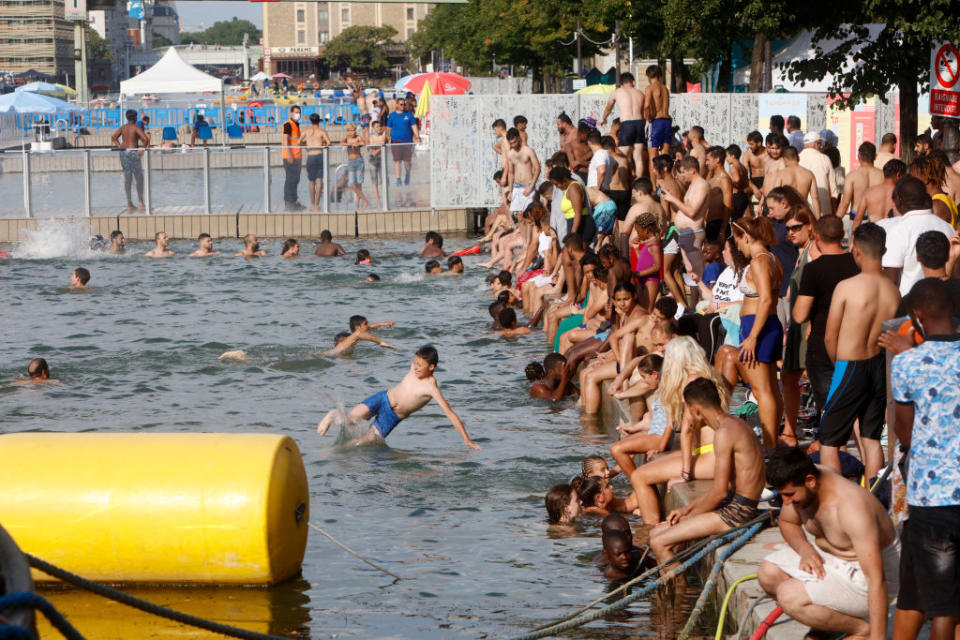 People dive into the water of the Canal de l'Ourq in Paris on Sunday (local time). 