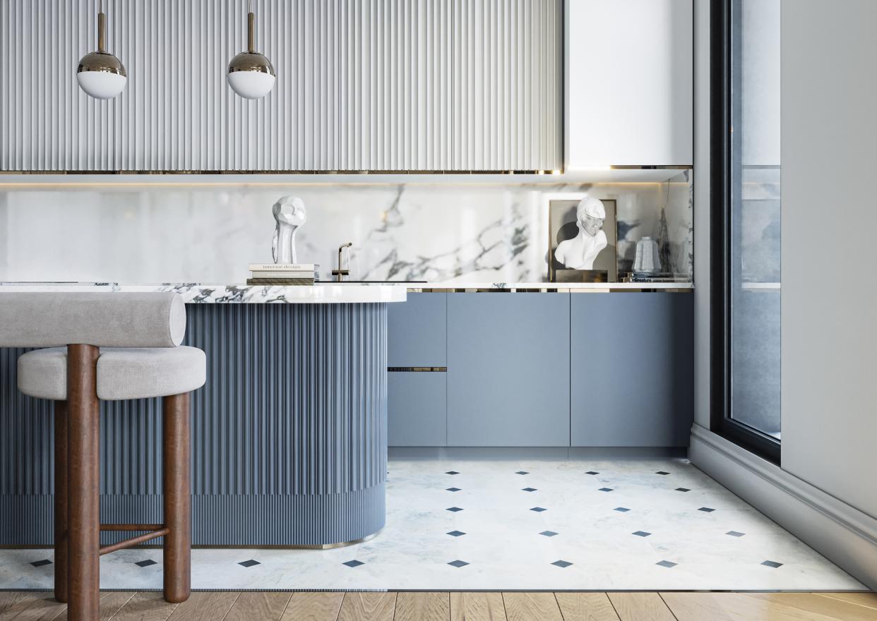  A kitchen with pastel blue cabinetry and marble countertop and backsplash 