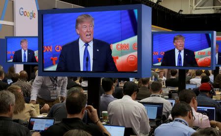 Journalists in the media filing center watch as Republican U.S. presidential candidate Donald Trump is seen speaking on television monitors during the debate sponsored by CNN for the 2016 Republican U.S. presidential candidates in Houston, Texas February 25, 2016. REUTERS/Richard Carson