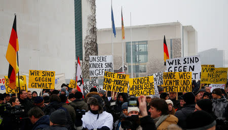 FILE PHOTO: Activists and supporters of the 'International Convention of German Russians' protest against sexual harassement by migrants in front of the Chancellery in Berlin, Germany, January 23, 2016. The placards read 'We are against violence', 'Today my child - tomorrow yours' and 'our children are in danger.' REUTERS/Hannibal Hanschke