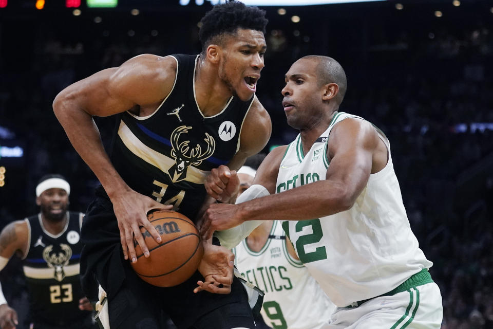 Boston Celtics center Al Horford (42) stops Milwaukee Bucks forward Giannis Antetokounmpo, left, on a drive to the basket during the first half of Game 5 of an Eastern Conference semifinal in the NBA basketball playoffs, Wednesday, May 11, 2022, in Boston. (AP Photo/Charles Krupa)