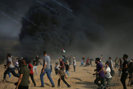 Tear gas canisters are fired by Israeli troops towards Palestinian demonstrators as they run during a protest demanding the right to return to their homeland at the Israel-Gaza border, in the southern Gaza Strip August 3, 2018. REUTERS/Ibraheem Abu Mustafa