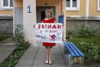 Halina Lahatskaya, 60, poses for a photo holding a poster that reads "come out to the people, coward" at an entrance of her apartment building in Minsk, Belarus, Saturday, Sept. 12, 2020. Lahatskaya, a 60-year-old construction engineer, said she tries to speak to riot police when she attends protests. "I'm trying to find something humane in them," she said. She argued that the Belarusian leader has lost public support, noting that even her 94-year-old father who always voted for Lukashenko cast his ballot for opposition candidate Sviatlana Tsikhanouskaya. (AP Photo)