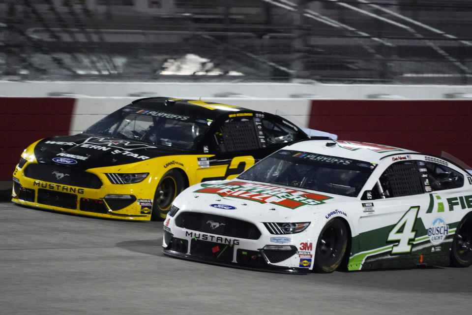 Brad Keselowski (2) and Kevin Harvick (4) drive into turn one during a NASCAR Cup Series auto race Saturday, Sept. 12, 2020, in Richmond, Va. (AP Photo/Steve Helber)