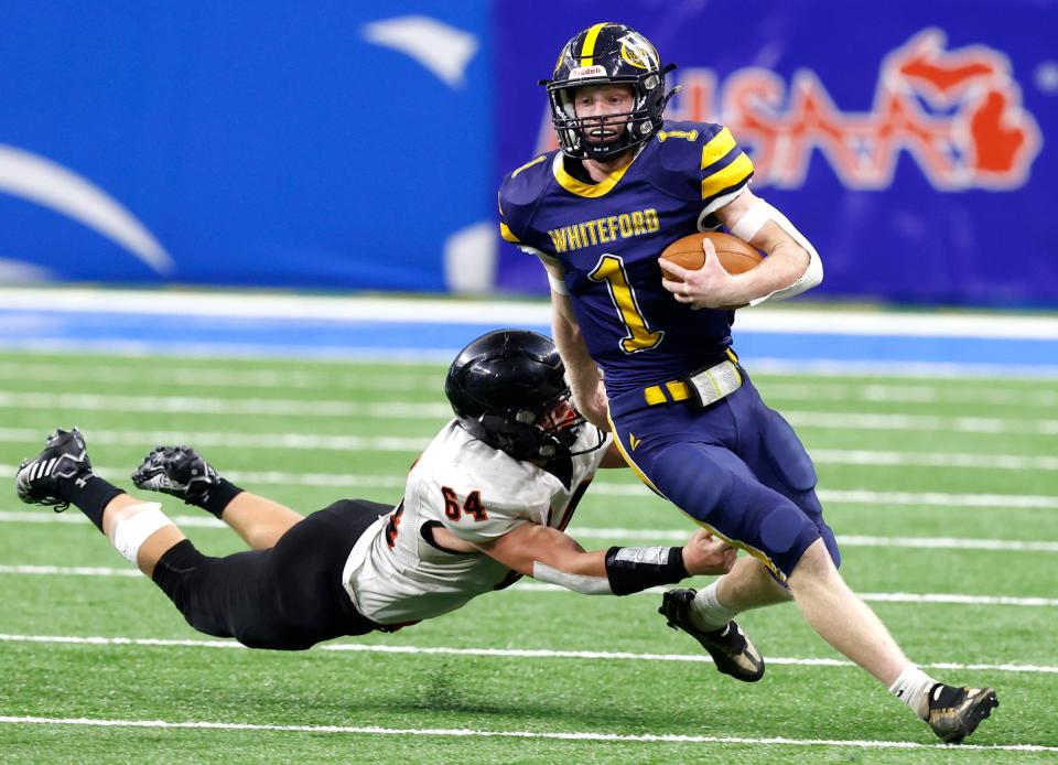 Ubly's Canden Peruski tries to stop a scrambling Ottawa Lake Whiteford quarterback Shea Ruddy during the second half of Whiteford's 26-20 win over Ubly in the Division 8 football final at Ford Field on Friday, Nov 25, 2022.