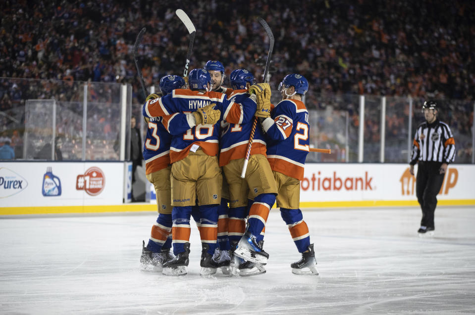 Edmonton Oilers celebrate after a goal against the Calgary Flames during third-period NHL Heritage Classic outdoor hockey game action in Edmonton, Alberta, Sunday, Oct. 29, 2023. (Jason Franson/The Canadian Press via AP)