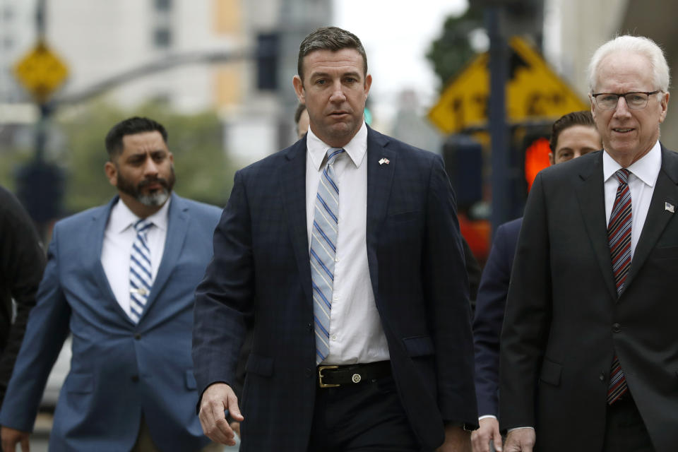 California Republican Rep. Duncan Hunter, center, walks towards federal court Tuesday, Dec. 3, 2019, in San Diego. Hunter said in a TV interview that aired Monday he plans to plead guilty to the misuse of campaign funds at a federal court hearing Tuesday in San Diego. (AP Photo/Gregory Bull)