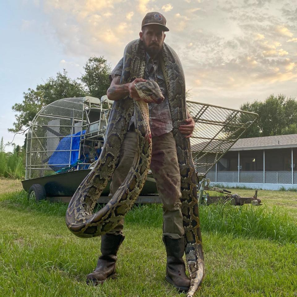Mike Kimmel, owner of Martin County Trapping & Wildlife Rescue, holds a five-metre Burmese python.