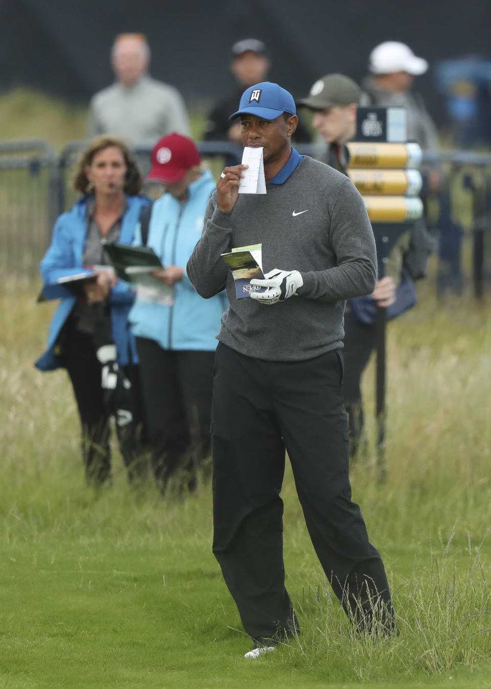 Tiger Woods of the United States looks at his playing guides on the 18th fairway during the first round of the British Open Golf Championships at Royal Portrush in Northern Ireland, Thursday, July 18, 2019.(AP Photo/Jon Super)