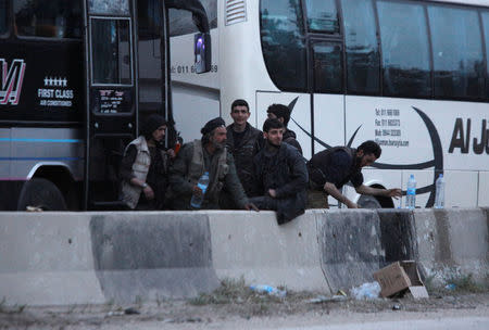 Rebels stand together as they wait to be evacuated, outisde Harasta in eastern Ghouta, in Damascus, Syria March 23, 2018. REUTERS/Omar Sanadiki